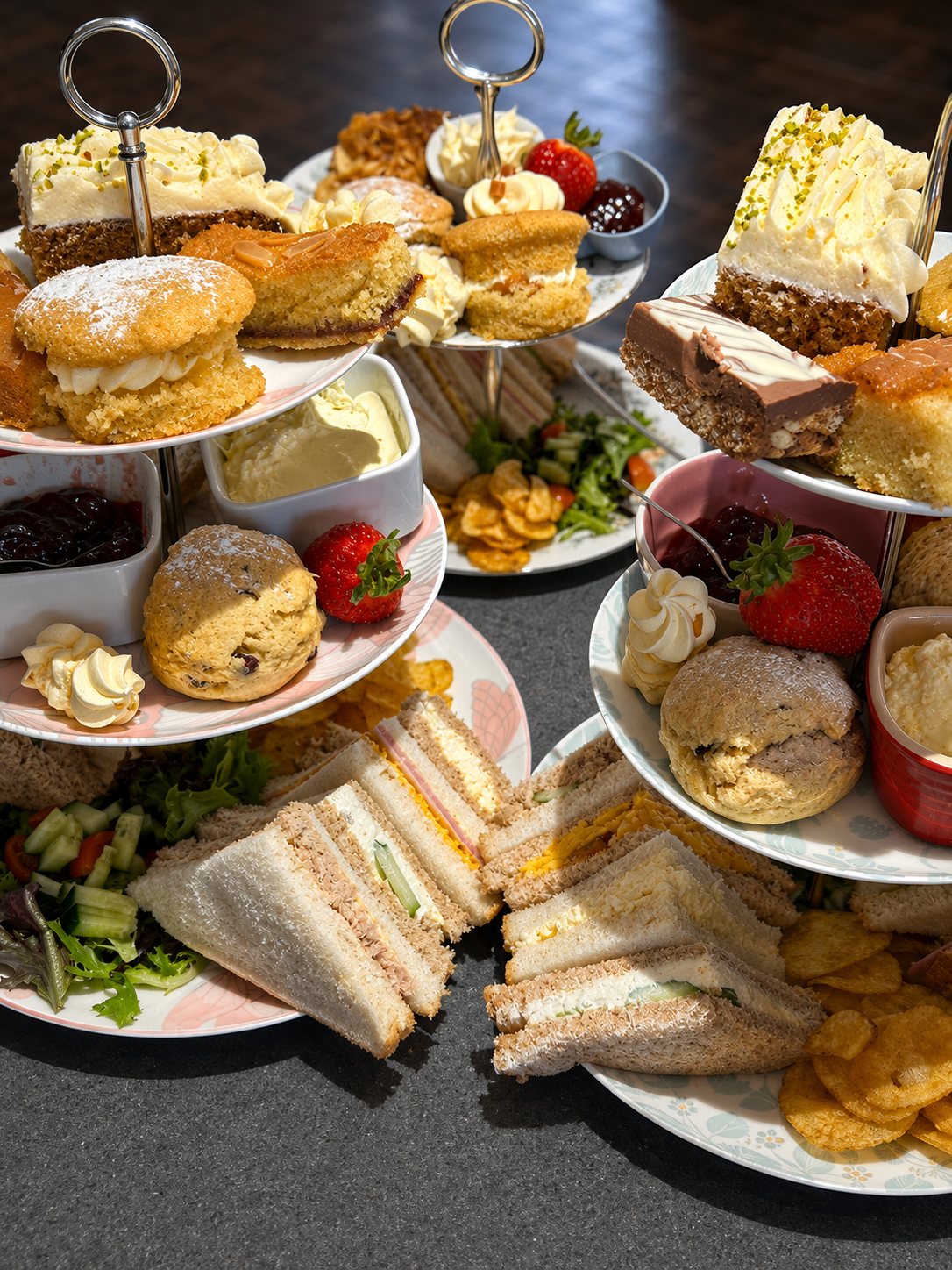 A generous afternoon tea spread of cakes, scones, sandwiches and fruit