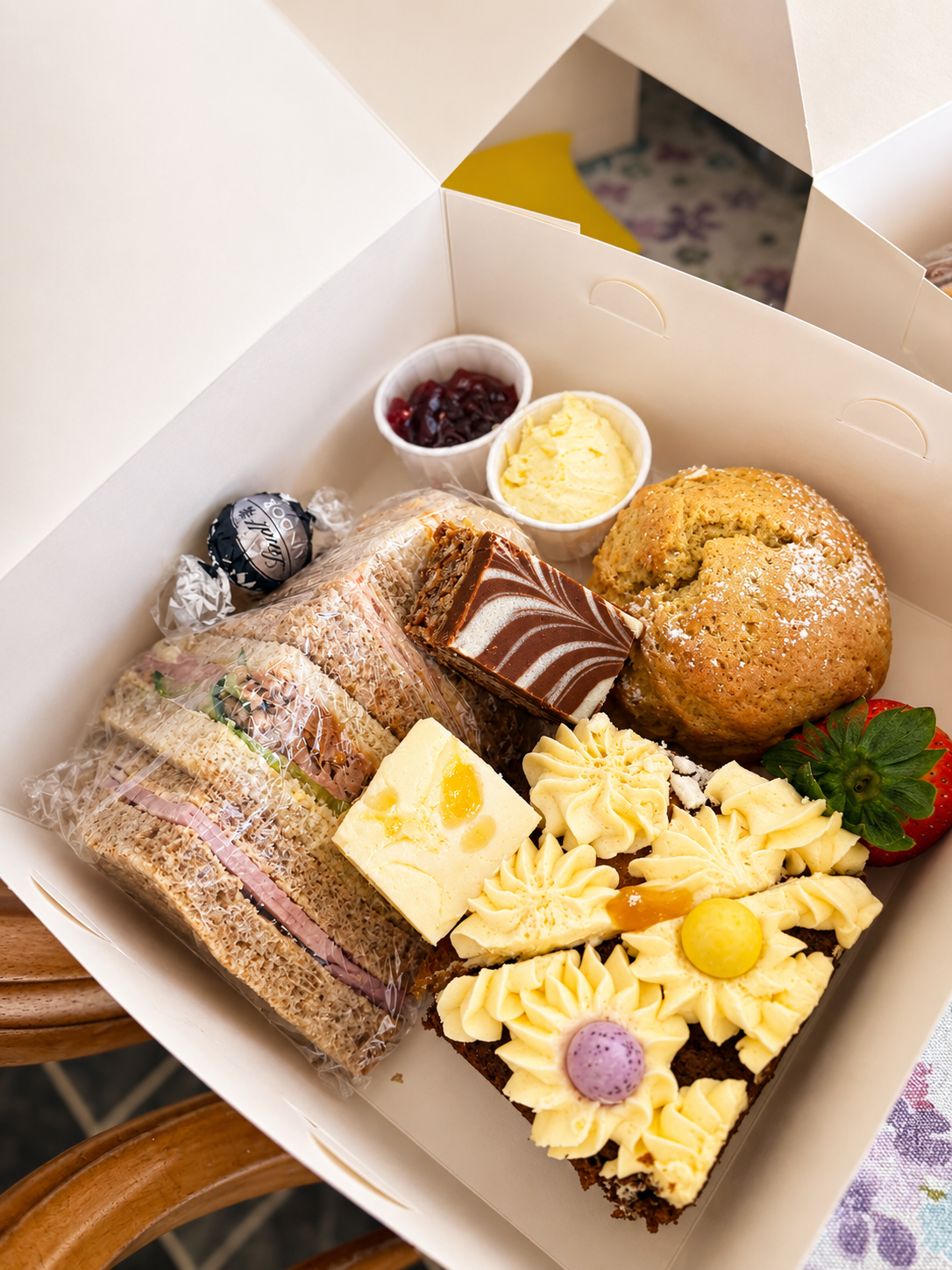 Afternoon tea boxes filled with sandwiches, cakes, fruit and treats