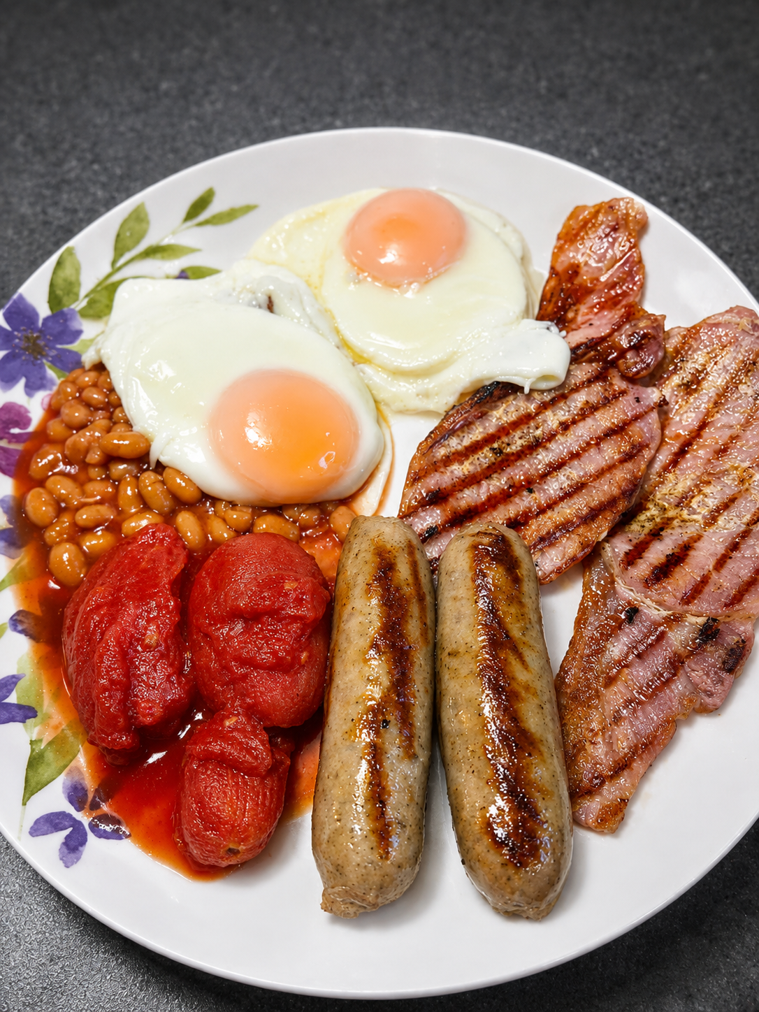 Full English breakfast with eggs, bacon, sausages, beans and tomatoes